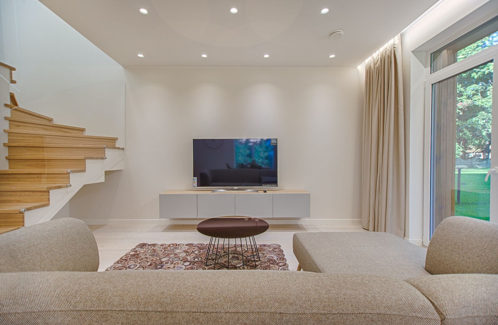 Bild på en moderna inredd källare med soffa, tv och takbelysning
